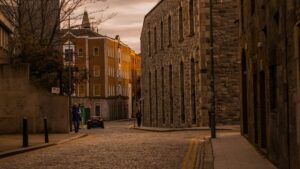 a cobblestone street with a clocktower in the background