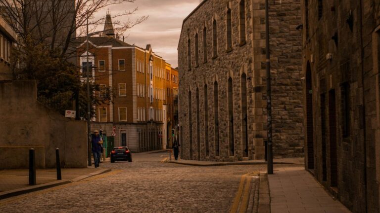 a cobblestone street with a clocktower in the background