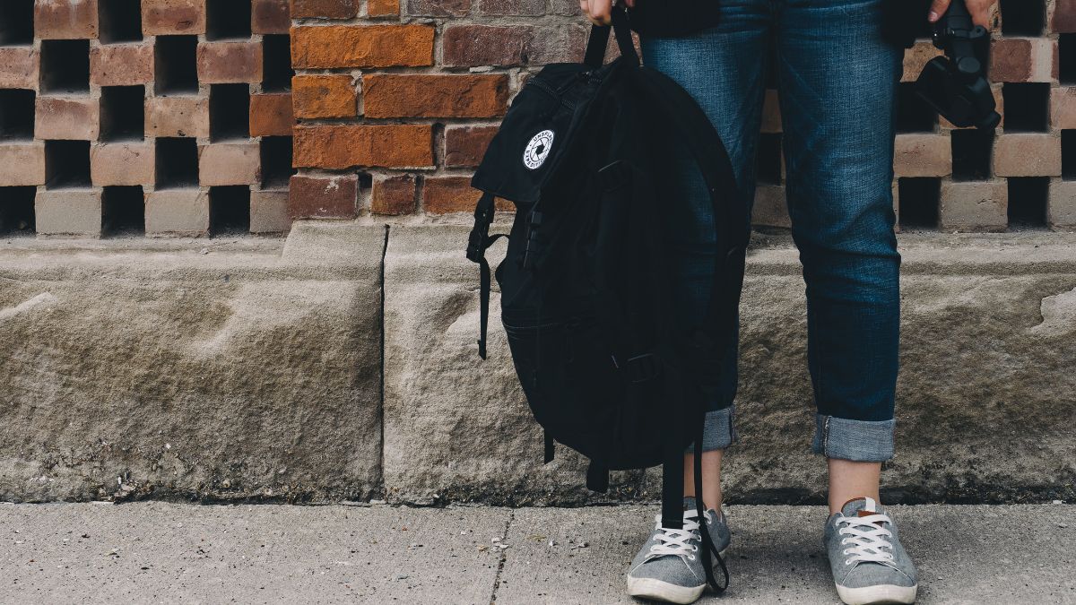 Tourist keeping travel backpack close