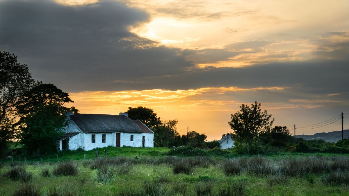 Old Irish thatched cottage at sunset