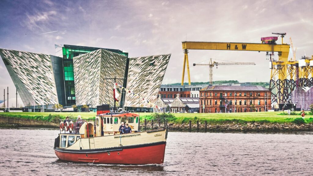 ferry on a river with the Titanic Belfast in the background